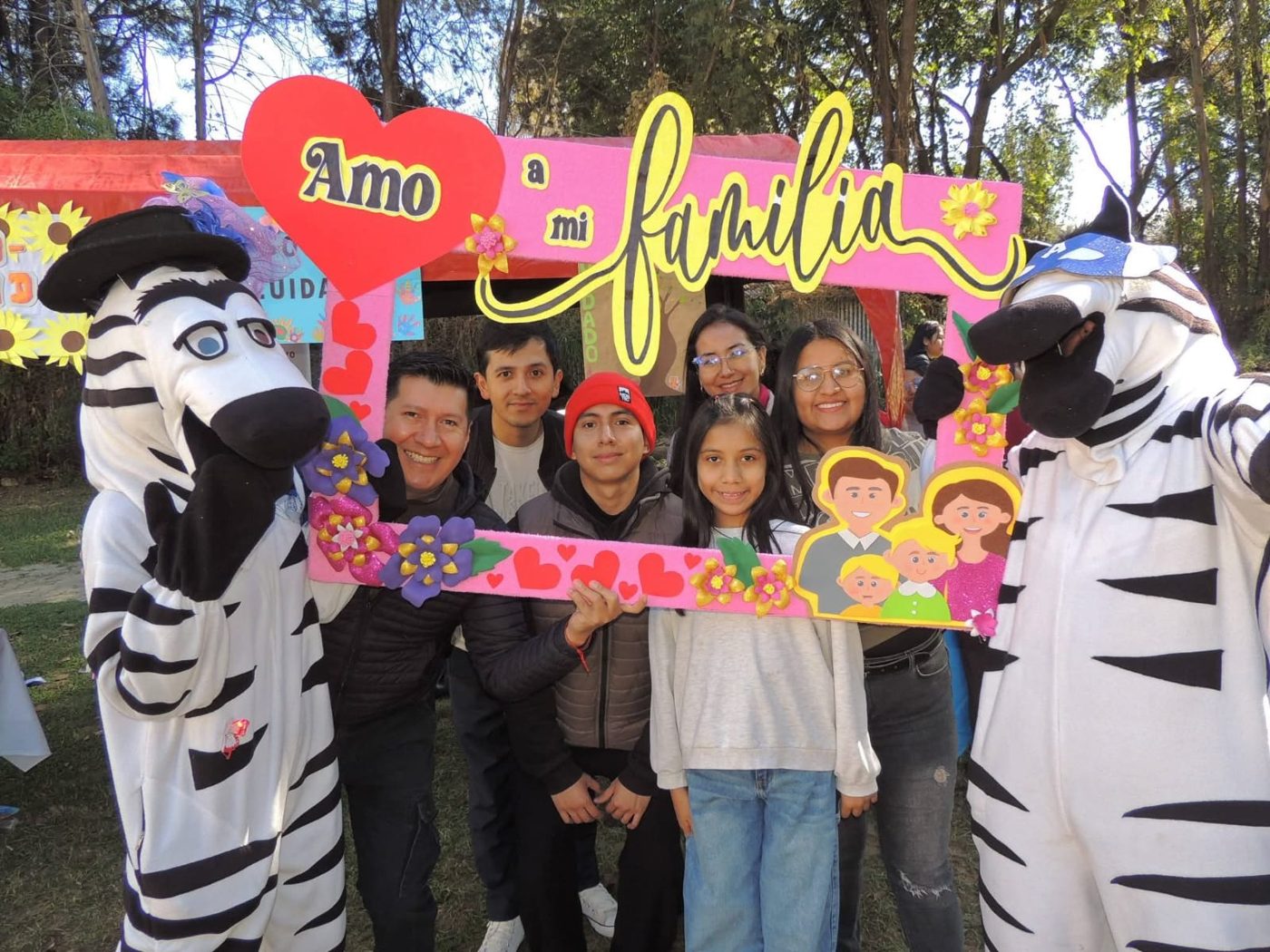 Familia en una feria comunitaria con el marco Amo a mi familia